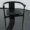 Black Accent Chair With Curved Arms And Slim Metal Legs In Modern Space