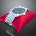 Elegant Silver Wristwatch on Red Cushion with Metal Strap and Classic Dial Design