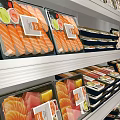 Stainless Steel Display Freezer with Multiple Shelves Holding Various Packaged Foods