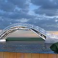 Modern Arch Bridge With White Railings Over Water Under Cloudy Sunset Sky