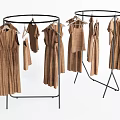 Round Clothes Rack With Black Metal Frame Holding Brown Dresses And Tops