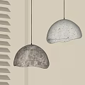 Two Hemispherical Concrete Pendant Lights With Warm Glow By Window Blinds