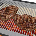 Juicy Grilled Steaks On Electric Grill With Red Heating Elements And Char Marks