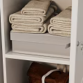 White Entryway Side Cabinet with Storage Baskets Folded Towels and Cactus Plants on Wooden Floor