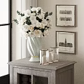 Light White Vase With White Flowers On Wooden Cabinet With Glass Candle Holders And Paintings