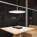 FLOS Round White Pendant Light Hanging Above Modern Table In Showroom Interior