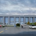 Modern Office Building With Glass Curtain Wall Exterior Parking Lot Cars Trees And Cloudy Sky