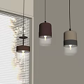 Modern Three Pendant Lights Transparent Brown Glass Shades Near Window Blinds Warm Yellow Illumination