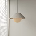 Modern Pendant Light Featuring Fabric Shade And Round Globe In Light Colored Room