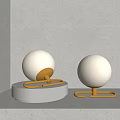 Two Modern Spherical Illuminated Table Lamps With Golden Brackets And White Bases