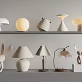 White Decorative Table Lamps With Various Creative Shapes Displayed On Shelves 3d model