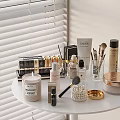 Perfume Cosmetics Arranged On White Table With Makeup Brushes Powder And Candle
