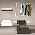 Modern Stylish Clothes Hanging On Hangers With White Pillows And Folded Blankets