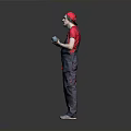 Man in Red Cap and Overalls Holding Power Tool Standing Against Gray Background