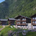 Scenic Mountain Guesthouse Building with Wooden Structure Balconies and Lush Green Surroundings