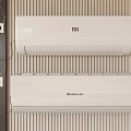 MI and GREE Air Conditioner Fan Units Mounted on Striped Wall with Power Sockets