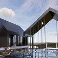 Modern Suspended Metallic Architectural Structure With Angular Roofs Over Grassland And Sky