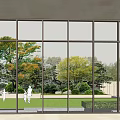 Hotel Building With Glass Facade Overlooking Garden Lawn And Trees