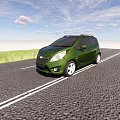 Green Compact Car Parked On Gravel Road With Blue Sky And Green Grass