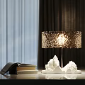 Modern Table Lamp With White Textured Base Sparkling Shade Warm Glow And Stack Of Books