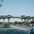 Modern Entrance Gate with Geometric Canopy Glass Roof and Prominent Logo Sign Surrounded by Trees