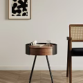 Stylish Round Wooden Console Table with Black Frame and Decorative Items Next to Rattan Chair