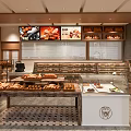Warm Mall Bakery Shop With Fresh Breads Pastries Glass Display Cases And Wooden Counters