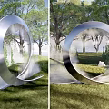 Large Metallic Ring Landscape Sculpture in Green Park with Trees and Water Flow