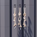 Three Beige Rope Pendant Lights With Knotted Design Featuring Bulbs On Gray Vertical Striped Wall