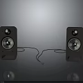 Black Speakers With Silver Drivers And Connecting Cable Placed On Grey Surface Against Dark Background 3d model