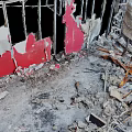 Damaged Building Interior With Collapsed Structures Broken Red Walls Debris And Wooden Fragments