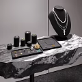 Elegant Jewelry Display Shelf with Necklace Small Black Cylinders Tray on Rock Textured Surface