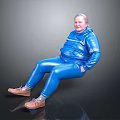 Woman in blue jumpsuit with white text sitting on black surface smiling in brown shoes