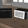 Modern Black and Silver Kitchen Appliances Microwave and Oven Placed on Wooden Table