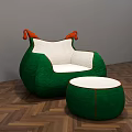 Green Armchair With White Cushion Orange Armrests And Matching Ottoman On Herringbone Wooden Floor
