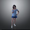 Woman Posing in Blue Off Shoulder Top Blue Shorts and White Shoes Against Gray Background