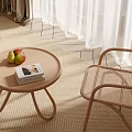 Round Woven Coffee Table With Fruit And Book Next To Rattan Chair On Carpet