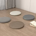 Round Gray and Brown Cushions on Wooden Floor with Stack of Books