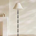 Modern Floor Lamp With Black Pole Cream Lampshade And Cylindrical Accents Near White Shelf