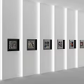 White Modern Background Wall With Six Black Framed Decorative Paintings And Vertical Light Strips
