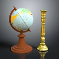 Vintage Globe With Brown Base And World Map Next To Golden Ornate Candle Holder