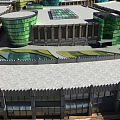 Modern Commercial Street Featuring Curved Glass Buildings Green Rooftops And Open Plaza Area