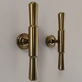 Two Sleek Modern Brass Cylindrical Handles Mounted on White Background