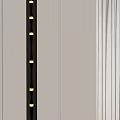 Modern Metallic Wall Lamp With Vertical LED Lights On Light Colored Wall And Gray Curtains