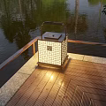 Outdoor Lantern With Square Lattice Design Illuminating Wooden Deck By Water