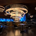 Modern Restaurant Interior Design With Chandelier Lighting Blue Accent Wall And Round Tables