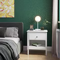 White Bedside Table with Round Lamp Photo Frame and Small Plant against Green Bedroom Wall