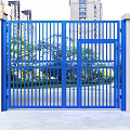Blue Metal Gate With Railing Design And Concrete Pillars Against High Rise Buildings And Greenery