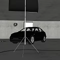 Black Car Being Photographed In Studio With Professional Lighting Equipment And Reflectors