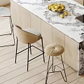 Modern Kitchen Interior With Marble Island Counter Dining Chairs Stools Sink Stove And Fruits